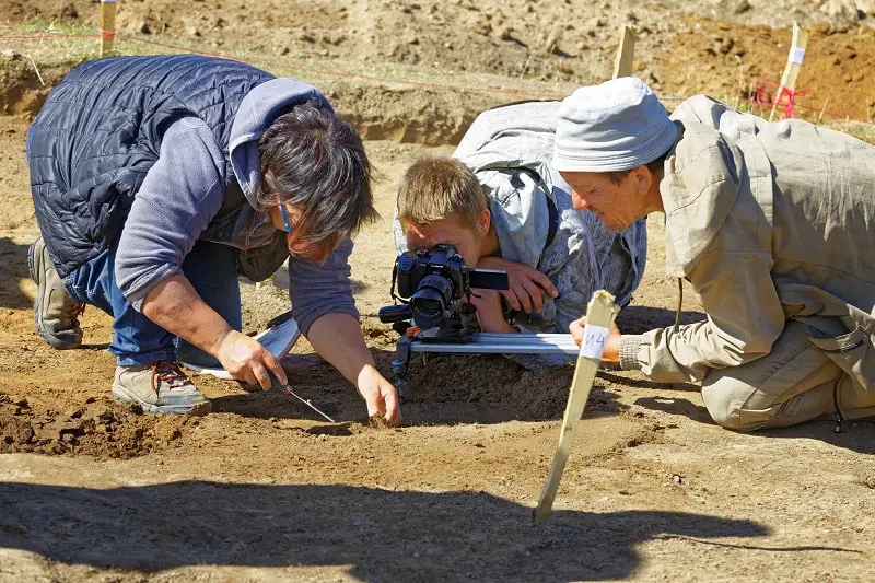 A group of archeologists at a dig site using GPR in the field.